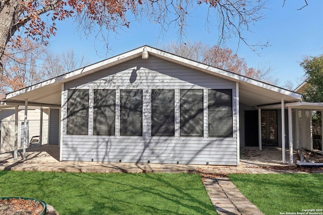 view of side of property with a carport and a yard