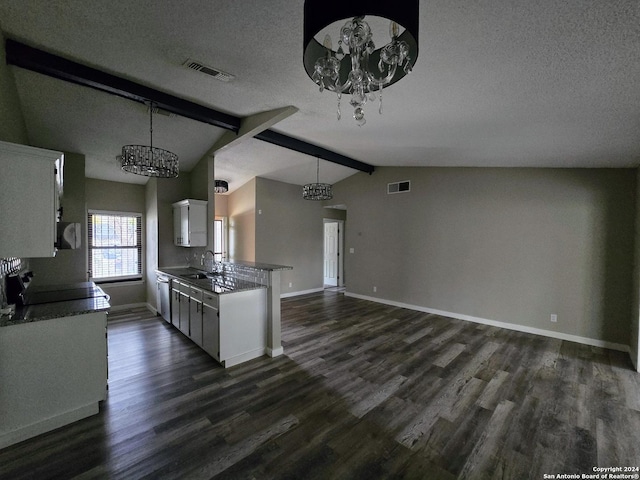 kitchen with white cabinetry, pendant lighting, lofted ceiling with beams, and a textured ceiling