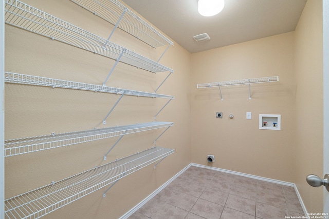 washroom with hookup for an electric dryer, washer hookup, tile patterned floors, and gas dryer hookup