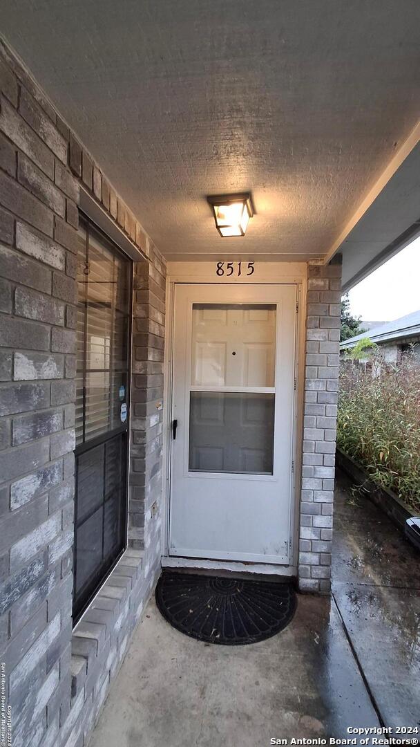 view of exterior entry with brick siding