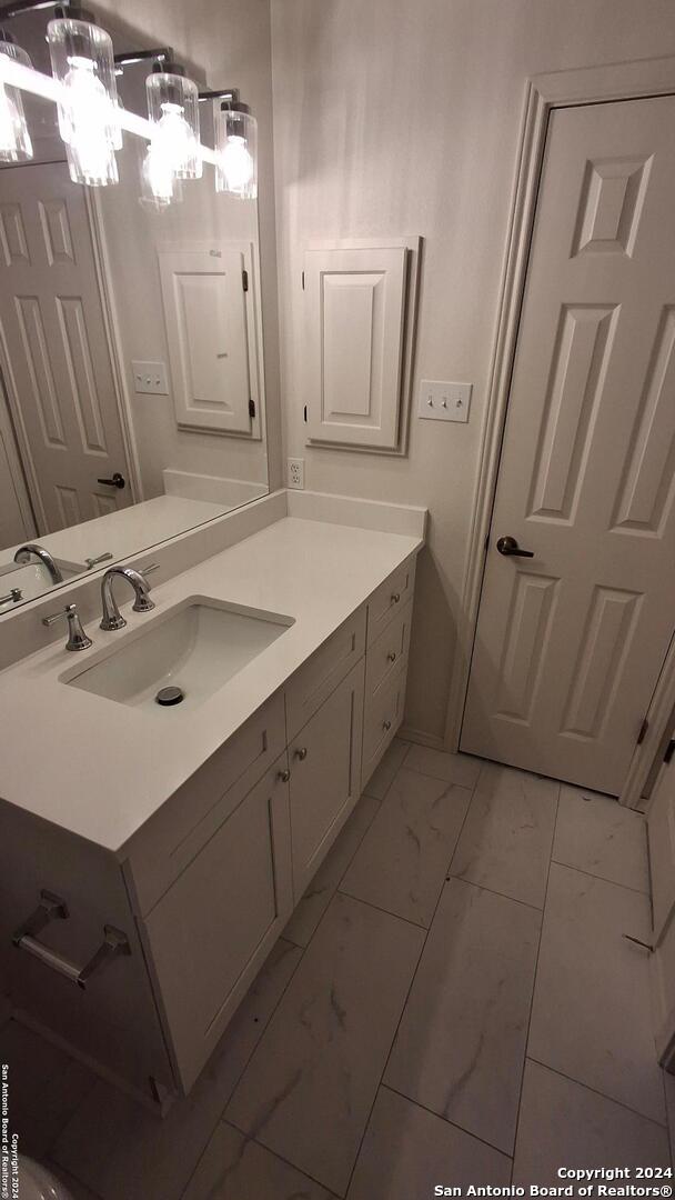 bathroom featuring marble finish floor and vanity