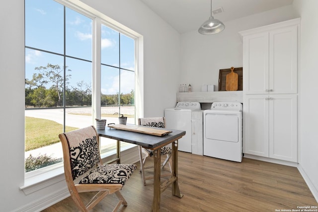 laundry room with cabinets, wood-type flooring, and washer and clothes dryer