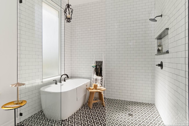 bathroom with tile patterned floors, independent shower and bath, and tile walls