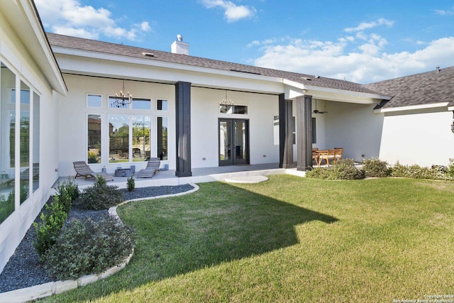 rear view of house featuring a patio area, a yard, and french doors