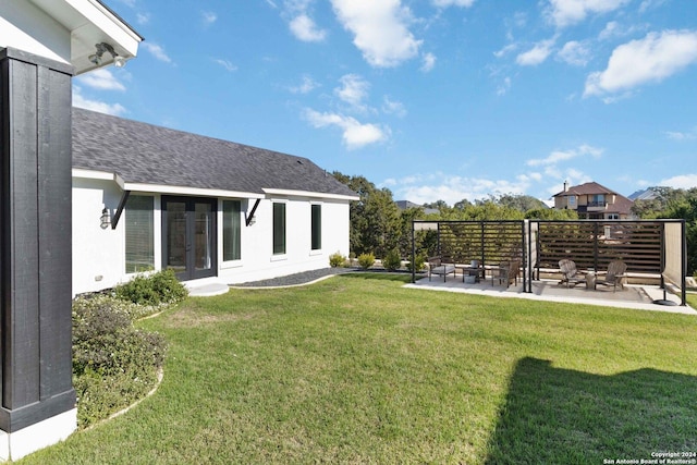 view of yard with a fire pit, a patio area, and french doors