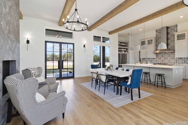 dining room featuring a chandelier, french doors, light wood-type flooring, and beam ceiling