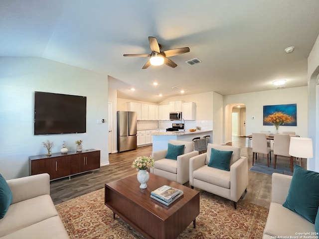 living room featuring ceiling fan, light hardwood / wood-style flooring, and vaulted ceiling