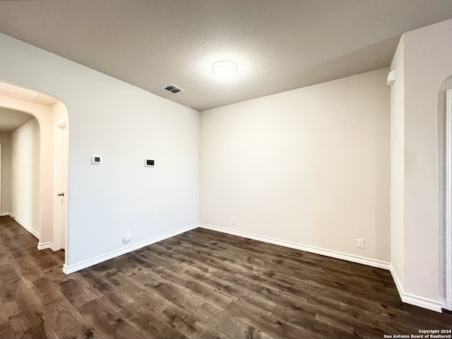 empty room featuring dark hardwood / wood-style floors and a textured ceiling