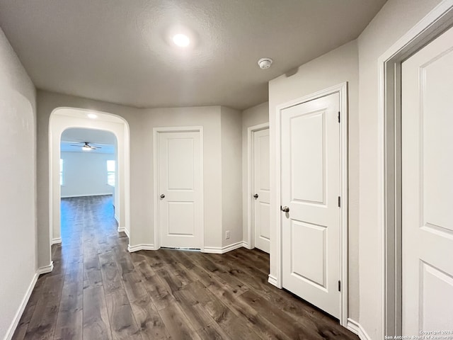 corridor featuring dark wood-type flooring and a textured ceiling