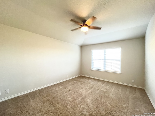 empty room with ceiling fan, carpet, and lofted ceiling