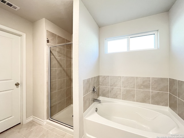 bathroom featuring tile patterned flooring and separate shower and tub