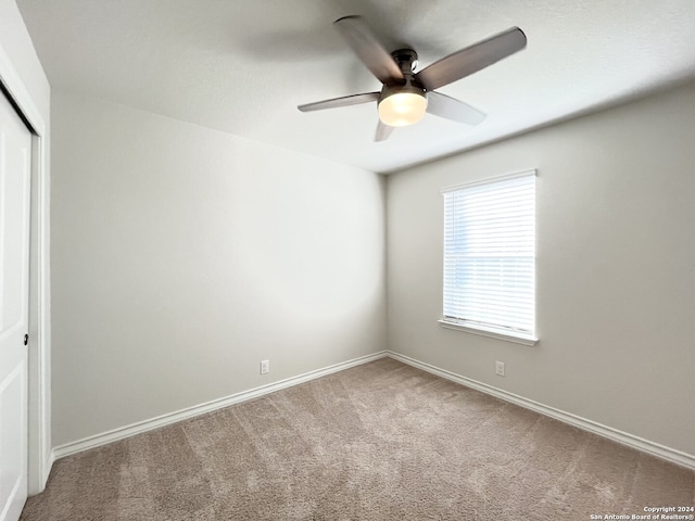 empty room with ceiling fan and carpet floors