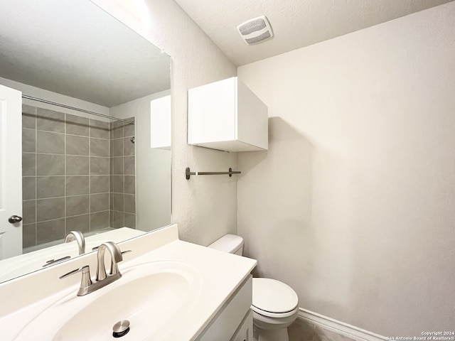 bathroom featuring a textured ceiling, vanity, and toilet