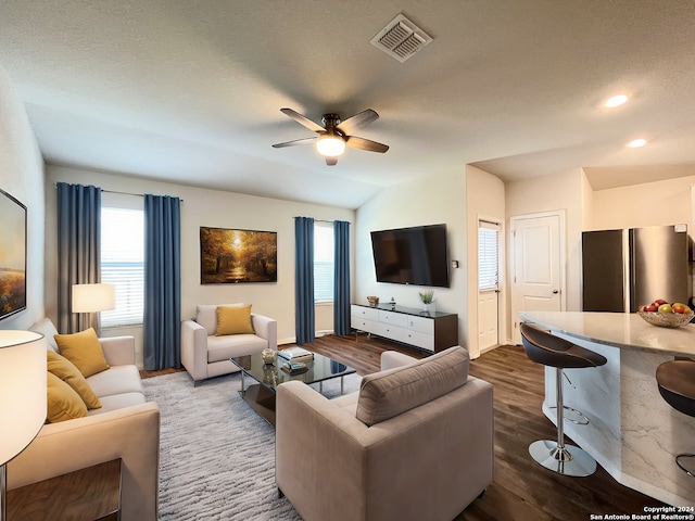 living room featuring ceiling fan, dark hardwood / wood-style flooring, plenty of natural light, and vaulted ceiling