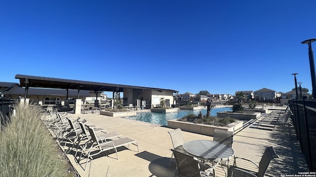 view of swimming pool featuring a water view and a patio