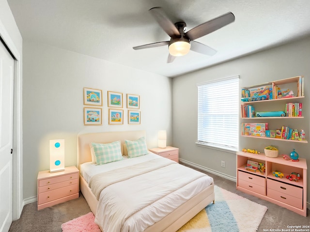 carpeted bedroom with ceiling fan and a closet