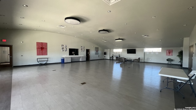 gym with brick ceiling, hardwood / wood-style floors, and lofted ceiling