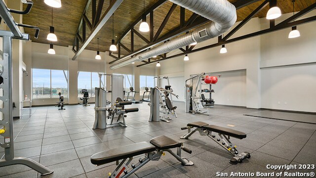 exercise room with wood ceiling and high vaulted ceiling