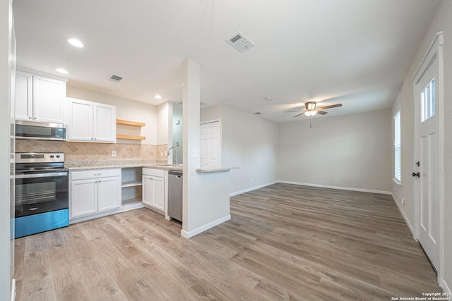 kitchen with white cabinets, decorative backsplash, ceiling fan, light wood-type flooring, and stainless steel appliances