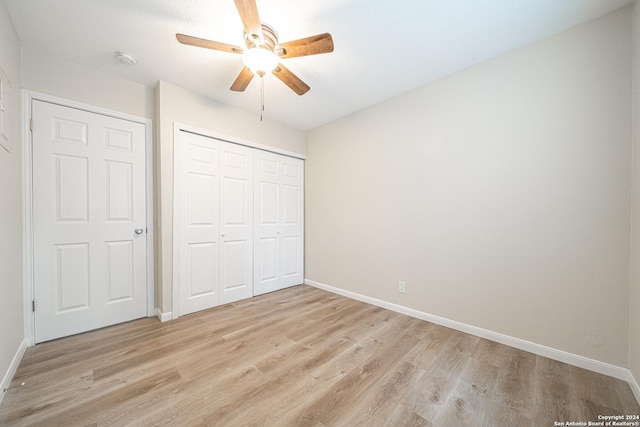 unfurnished bedroom featuring light wood-type flooring, a closet, and ceiling fan