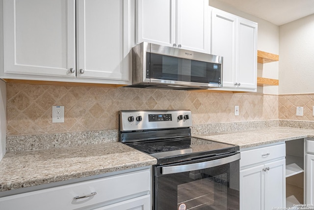 kitchen with decorative backsplash, white cabinetry, and appliances with stainless steel finishes