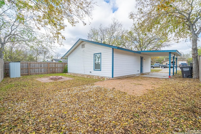 exterior space with a carport and a fire pit