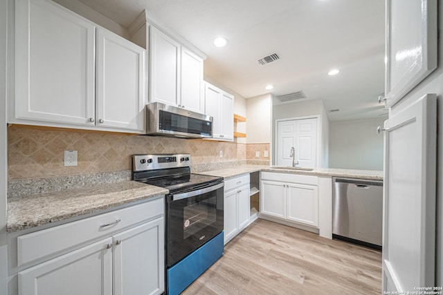 kitchen with white cabinetry, sink, appliances with stainless steel finishes, and light hardwood / wood-style flooring