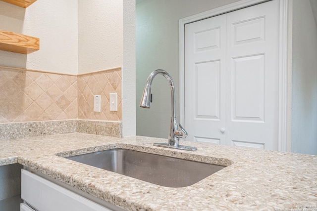 room details with light stone countertops and sink