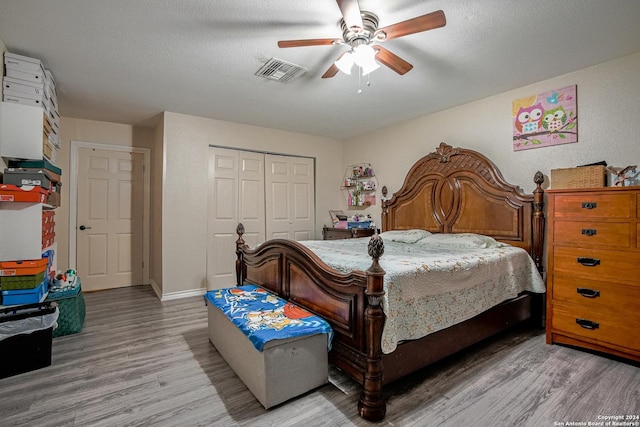 bedroom featuring hardwood / wood-style flooring, ceiling fan, a textured ceiling, and a closet