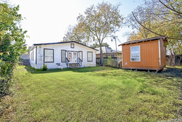 rear view of house featuring a shed and a yard