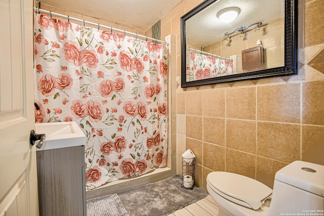 bathroom featuring tile walls, a shower with curtain, a textured ceiling, and toilet