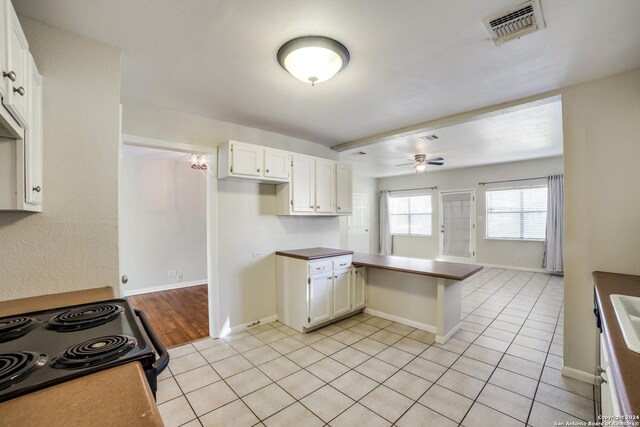 kitchen featuring white cabinets, ceiling fan, light tile patterned floors, black / electric stove, and kitchen peninsula