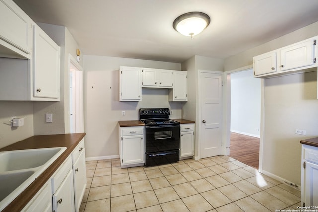 kitchen with white cabinets, light tile patterned flooring, and black range with electric cooktop