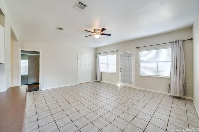 tiled spare room with ceiling fan