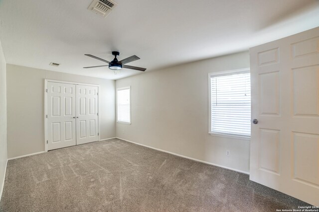 unfurnished bedroom featuring carpet, a closet, and ceiling fan