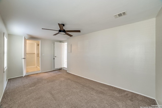 carpeted spare room featuring ceiling fan