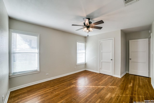 unfurnished bedroom with ceiling fan and dark wood-type flooring