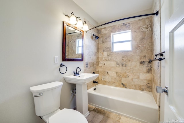 bathroom with tiled shower / bath combo and toilet