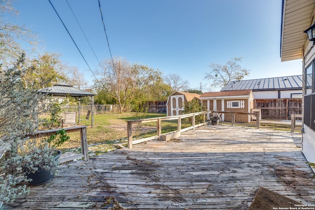 wooden deck with a gazebo and a storage shed