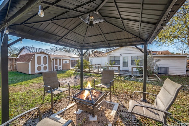 view of patio / terrace with a gazebo, a shed, a fire pit, and central AC unit