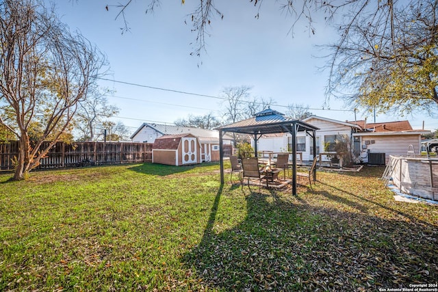 view of yard with a gazebo, a shed, and central AC