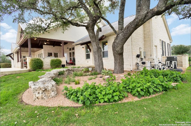 view of front of property featuring ceiling fan, a front lawn, and a patio