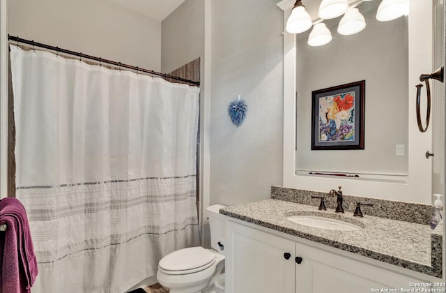 bathroom featuring curtained shower, vanity, and toilet