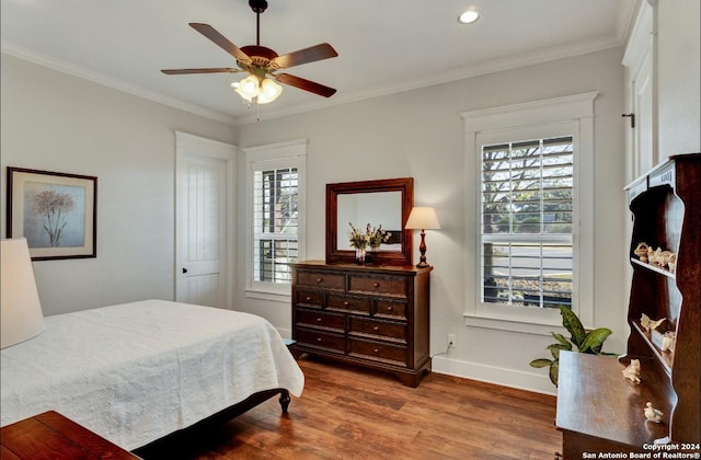 bedroom with wood-type flooring, ceiling fan, and crown molding