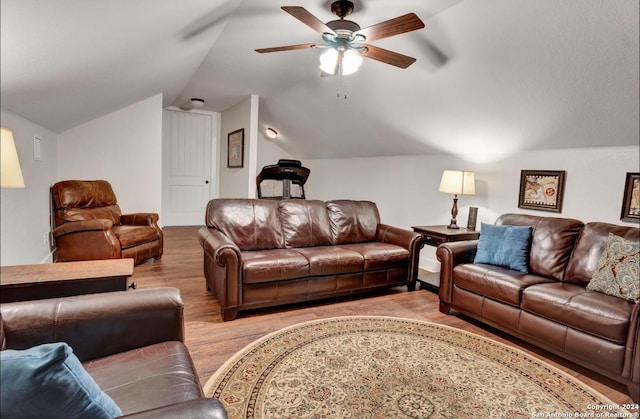 living room featuring ceiling fan, light hardwood / wood-style floors, and vaulted ceiling