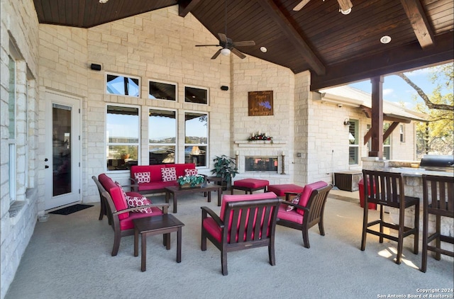 view of patio / terrace with an outdoor living space with a fireplace, an outdoor bar, ceiling fan, and a grill