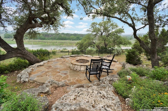 view of patio with a water view and an outdoor fire pit