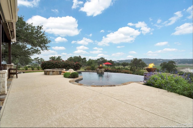 view of swimming pool featuring an in ground hot tub and a patio