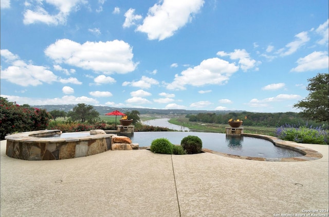 view of pool with a patio area and a water view