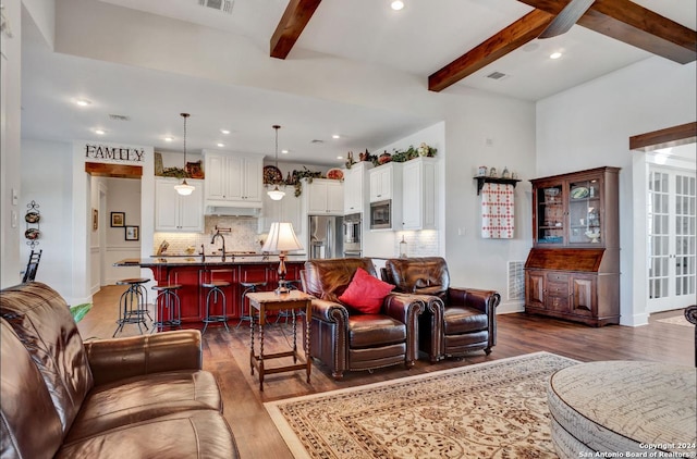 living room with beam ceiling and dark hardwood / wood-style flooring